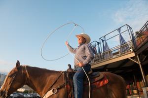 Cowboy performing a lasso trick on horseback at a Western-themed event—authentic entertainment from a North Texas destination management company.