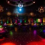 Colorful neon-lit nightclub with disco ball and creative lighting elements—bold and vibrant atmosphere created by Texas corporate event planners.